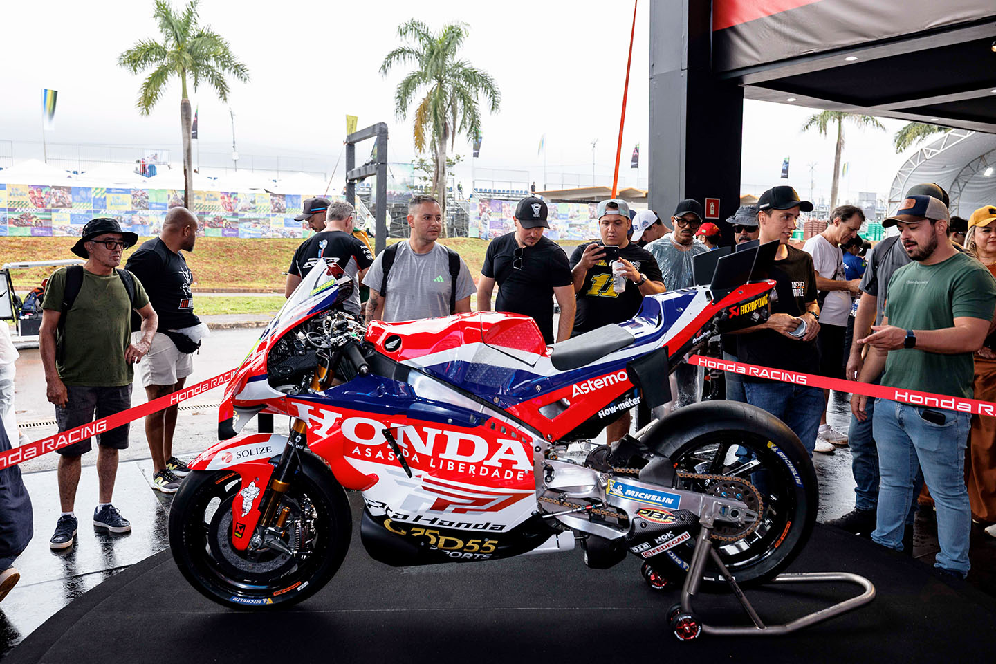 Moto de corrida da Honda exposta no estande do MotoGP em Goiânia, cercada por visitantes do evento